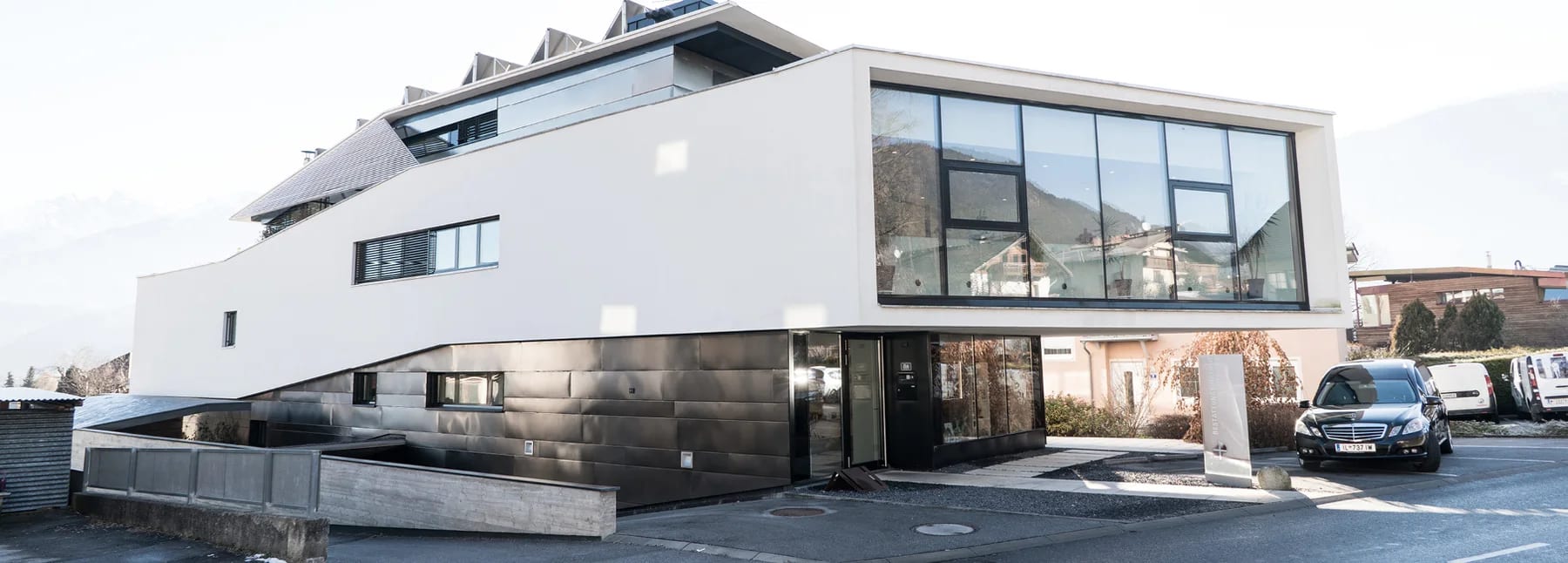 Außenansicht des Bestattungsinstituts Neurauter mit Zufahrt und Parkmöglichkeit