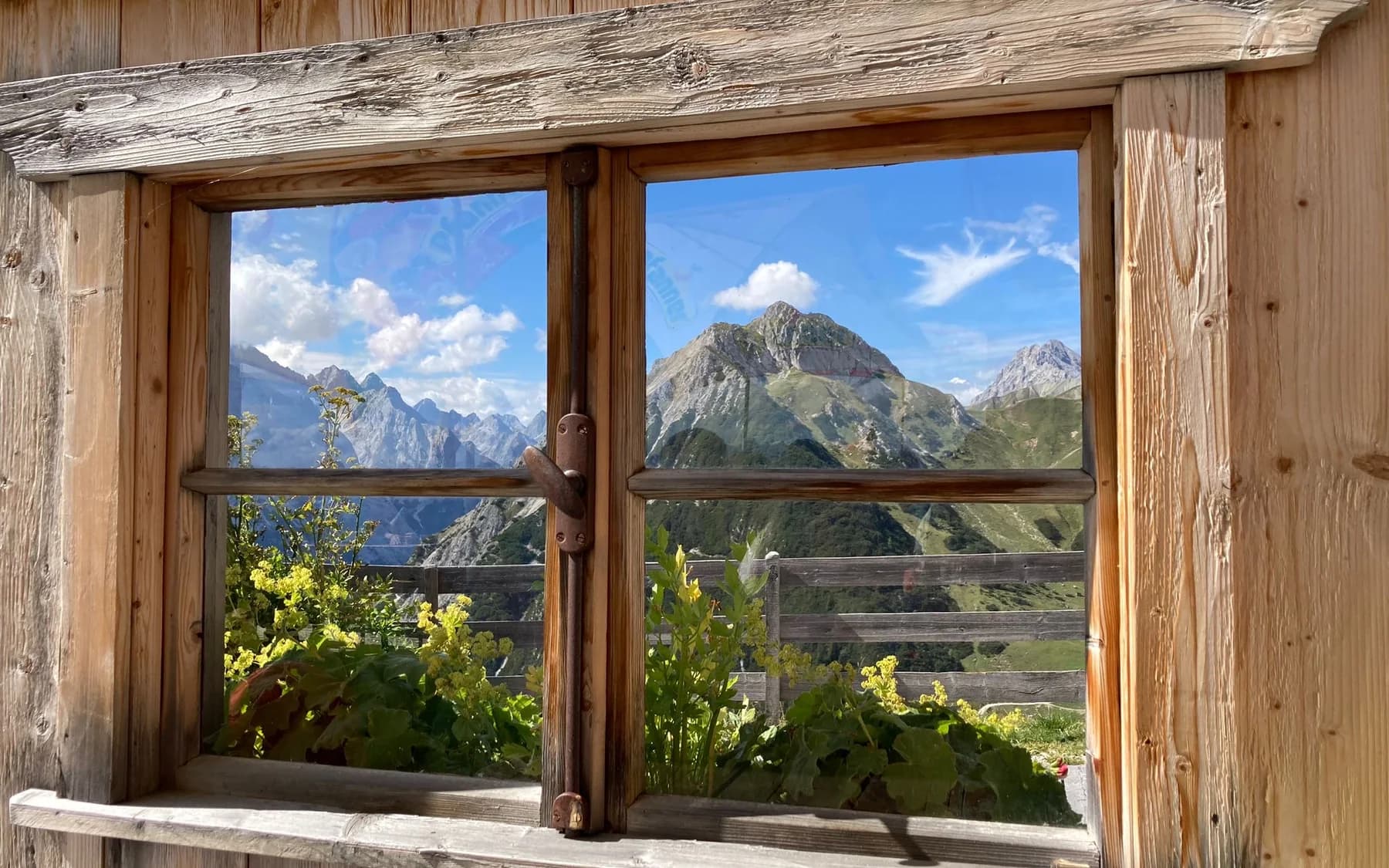 Ruhiger Bergblick durch ein Fenster als Symbol für eine Bestattungsvorsorge